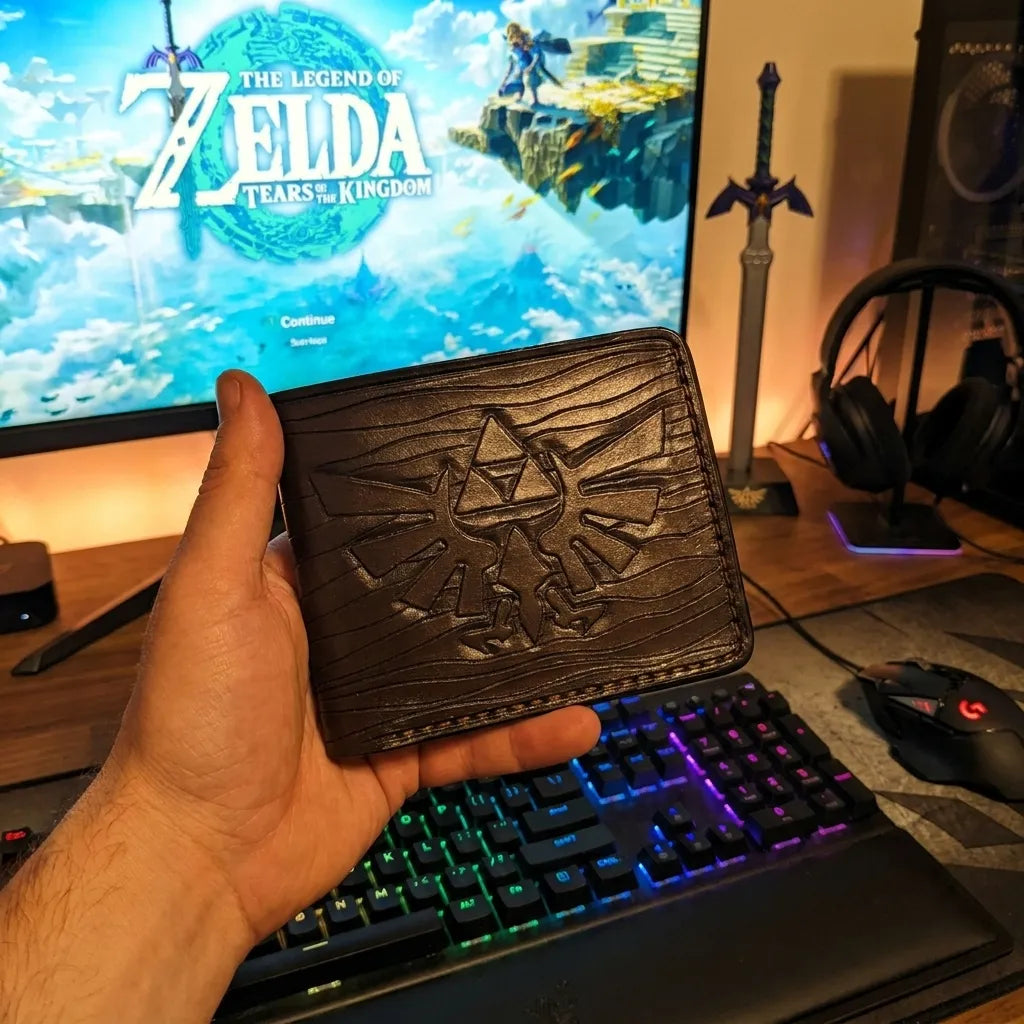 Luxury Zelda Ocarina of Time themed leather LOZ wallet held over an RGB gaming desk setup, perfect geek gift for gamers.
