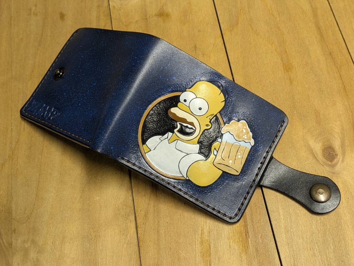Open Theodoros leather bifold wallet featuring hand-carved Homer Simpson design and secure metal snap closure.