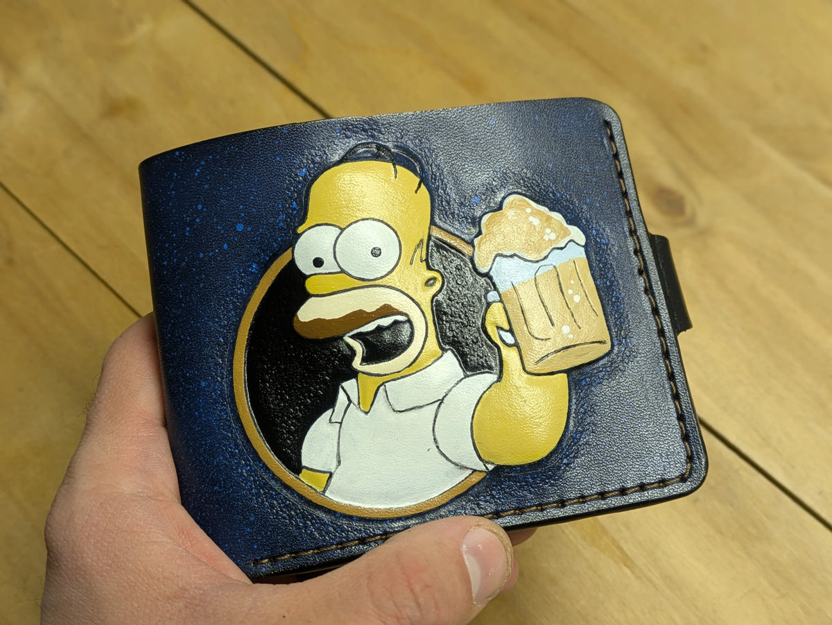 Close-up of artisan hand-tooled Homer Simpson wallet with high-detail painting on premium textured blue leather.