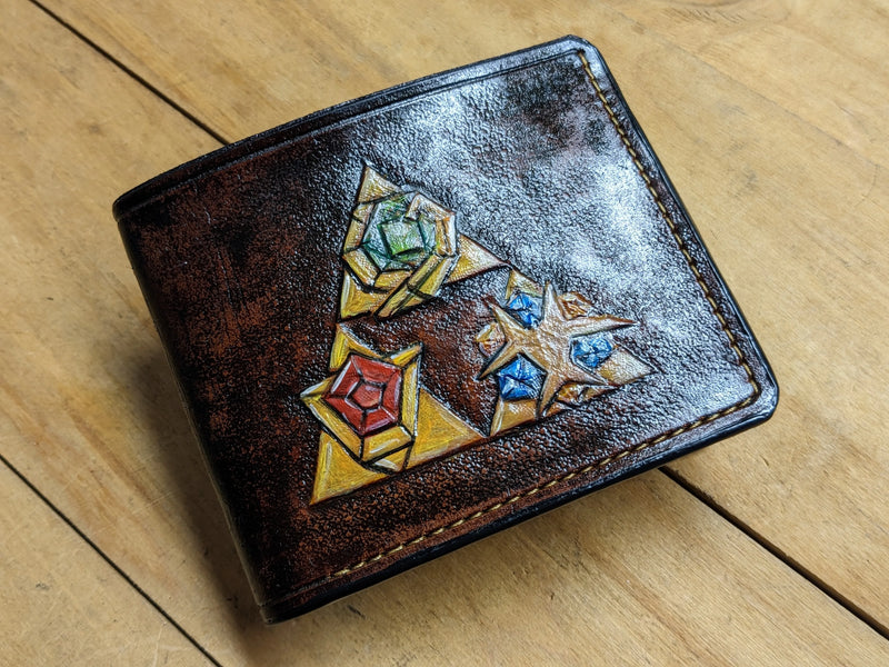 Unique hand-tooled leather Zelda gamer wallet featuring painted LOZ Ocarina of Time artifacts, crafted by Theodoros artisans.