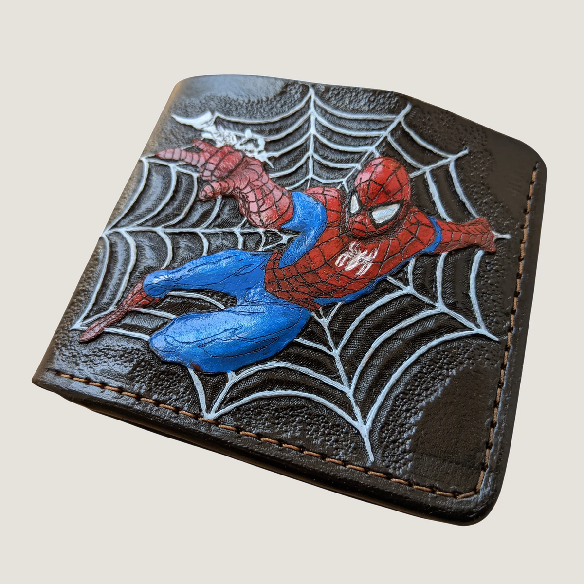 Hand-tooled full-grain leather Spider-Man wallet featuring a hand-painted and carved of Spiderman custom made by Theodoros.