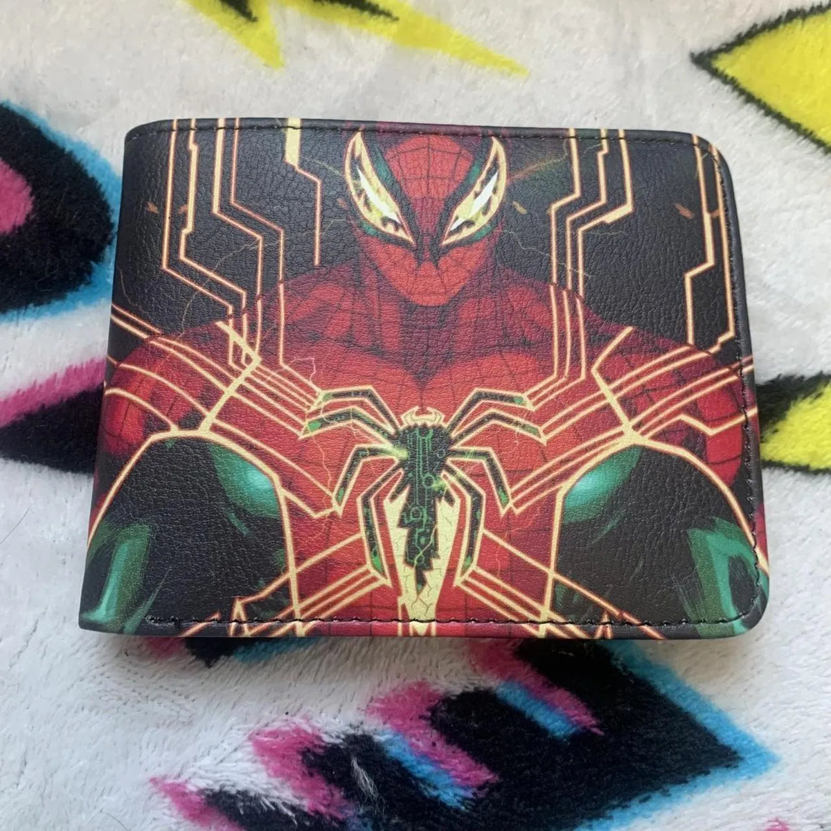 Front view of a black bifold leather wallet featuring a futuristic hand-painted graphic of Spider-Man on a colorful blanket.