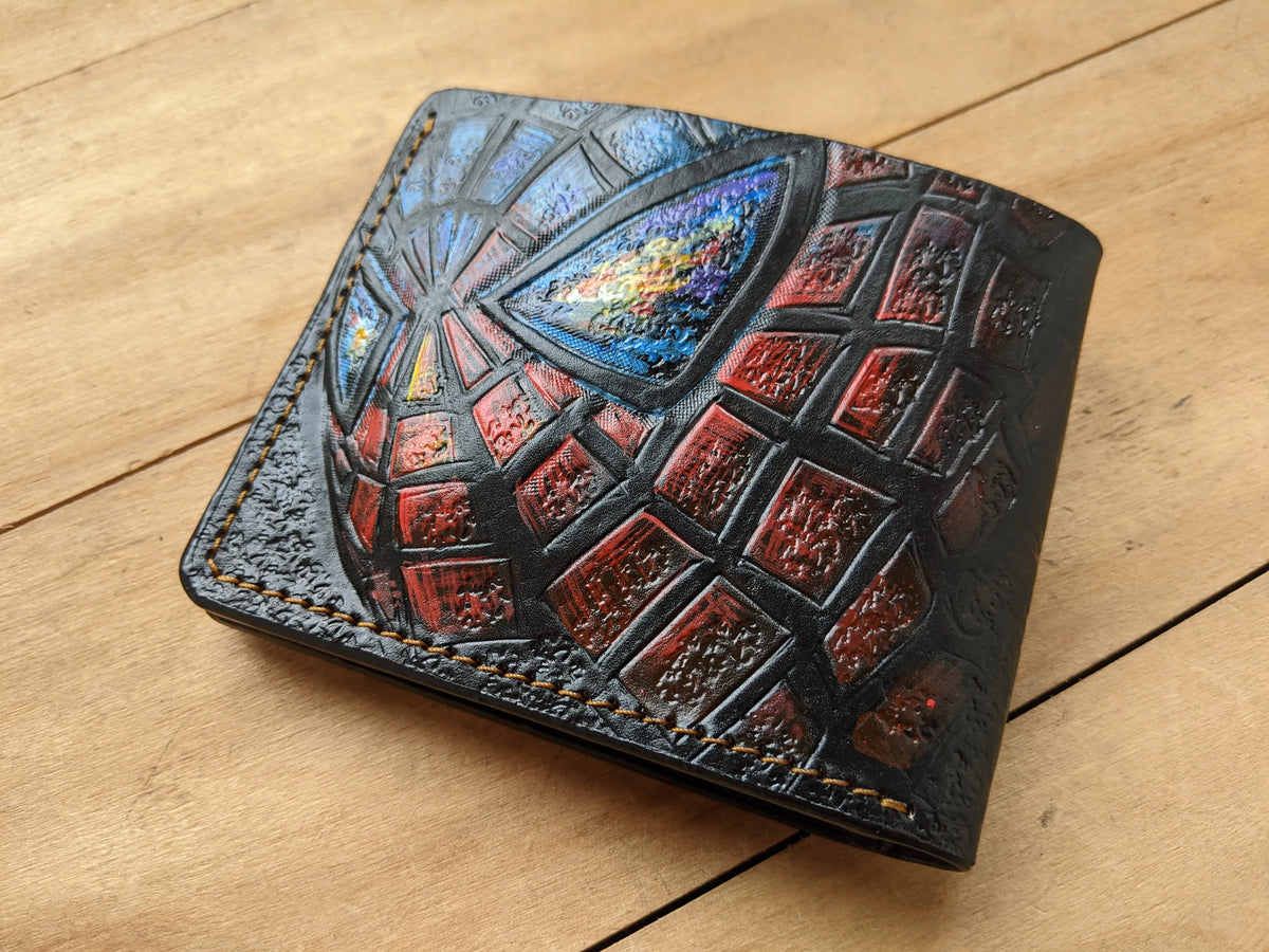 Close-up of a Spider-Man full-grain leather bifold wallet by Theodoros Leather showing detailed hand-tooled textures.